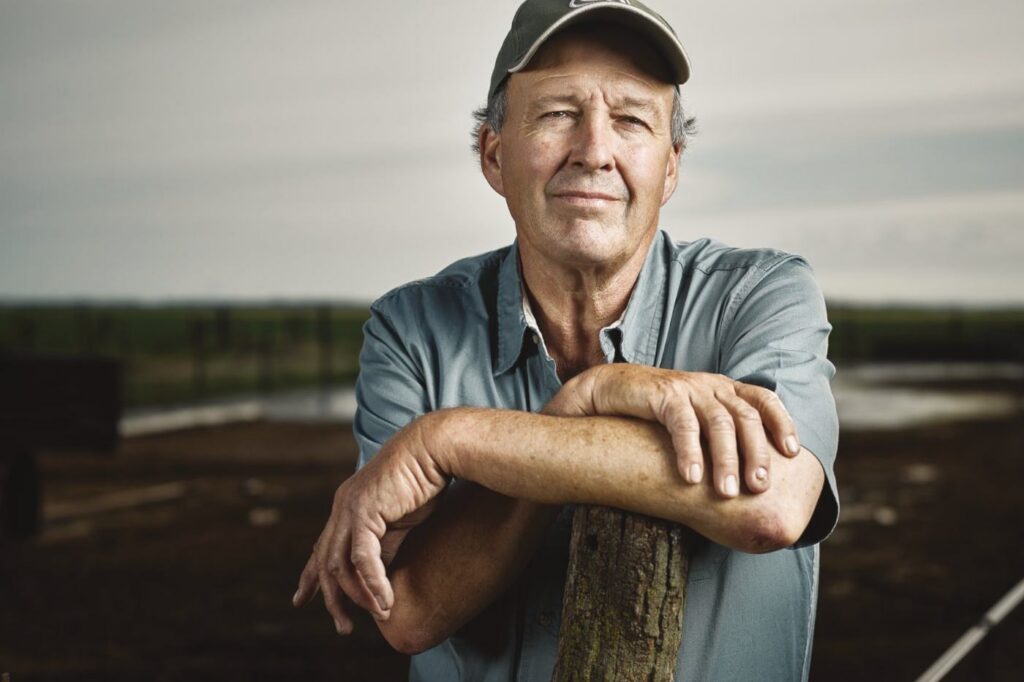 Livestock agent leaning on a fence post at the yards